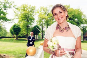 Bruidsfotograaf Limburg - scherpte diepte foto met stralende bruid op voorgrond.