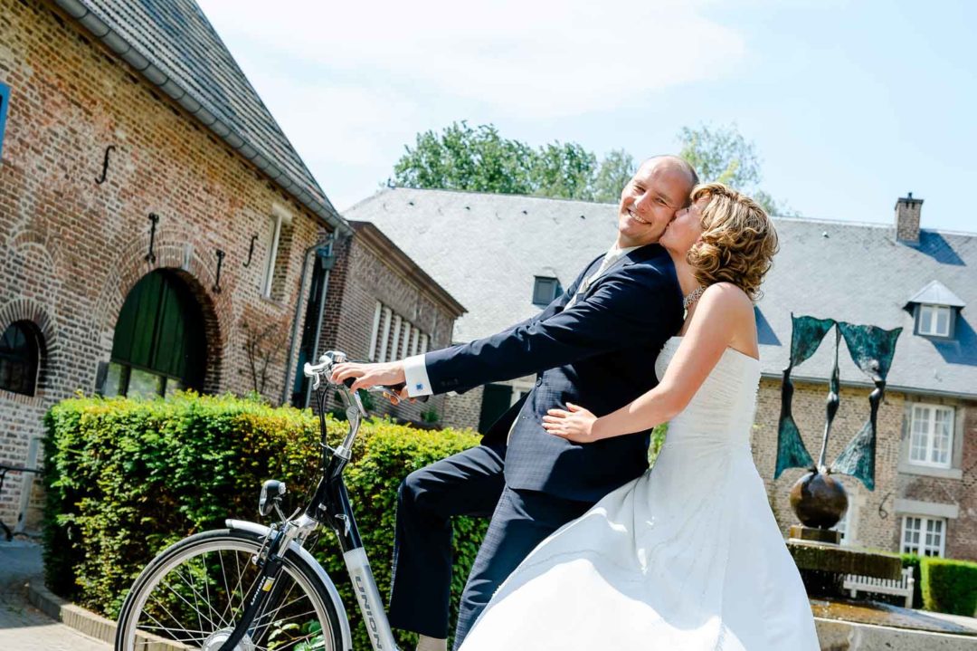 Het bruidspaar had een fiets gevonden bij Kasteel ter Worm in Heerlen. Ze zagen er gelukkig en verliefd uit. De bruid droeg een mooie, witte jurk. De bruidegom was gekleed in een strak donker pak met een wit overhemd en een zijden stropdas. Samen vormden ze een beeldschoon paar. Na een tijdje rond te hebben gefietst en foto's te hebben gemaakt, besloten we om weer terug te gasten naar de gasten van de bruiloft om door het trouwfeest verder te vieren