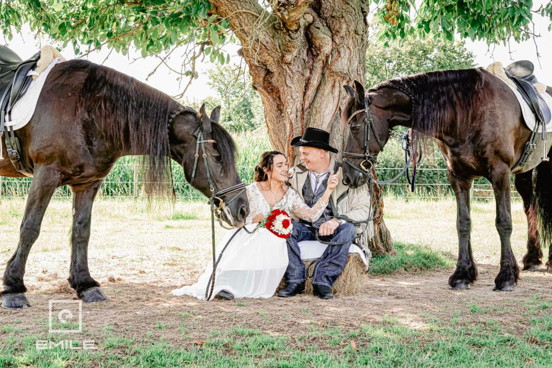 Bruidspaar onder de boom samen met paarden en alles in country en western stijl