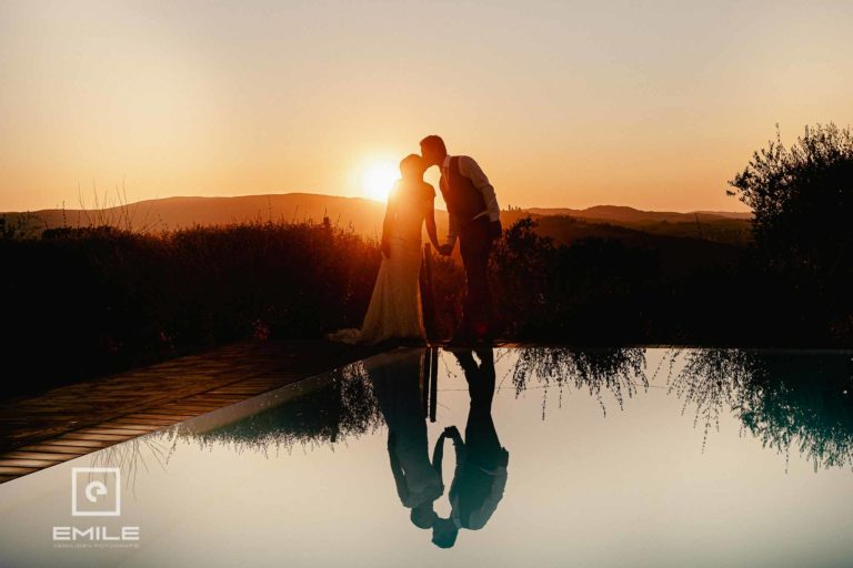 Destination wedding Italie Toscane - San Gimignano - bruidspaar bij ondergaande zon met reflectie in zwembad