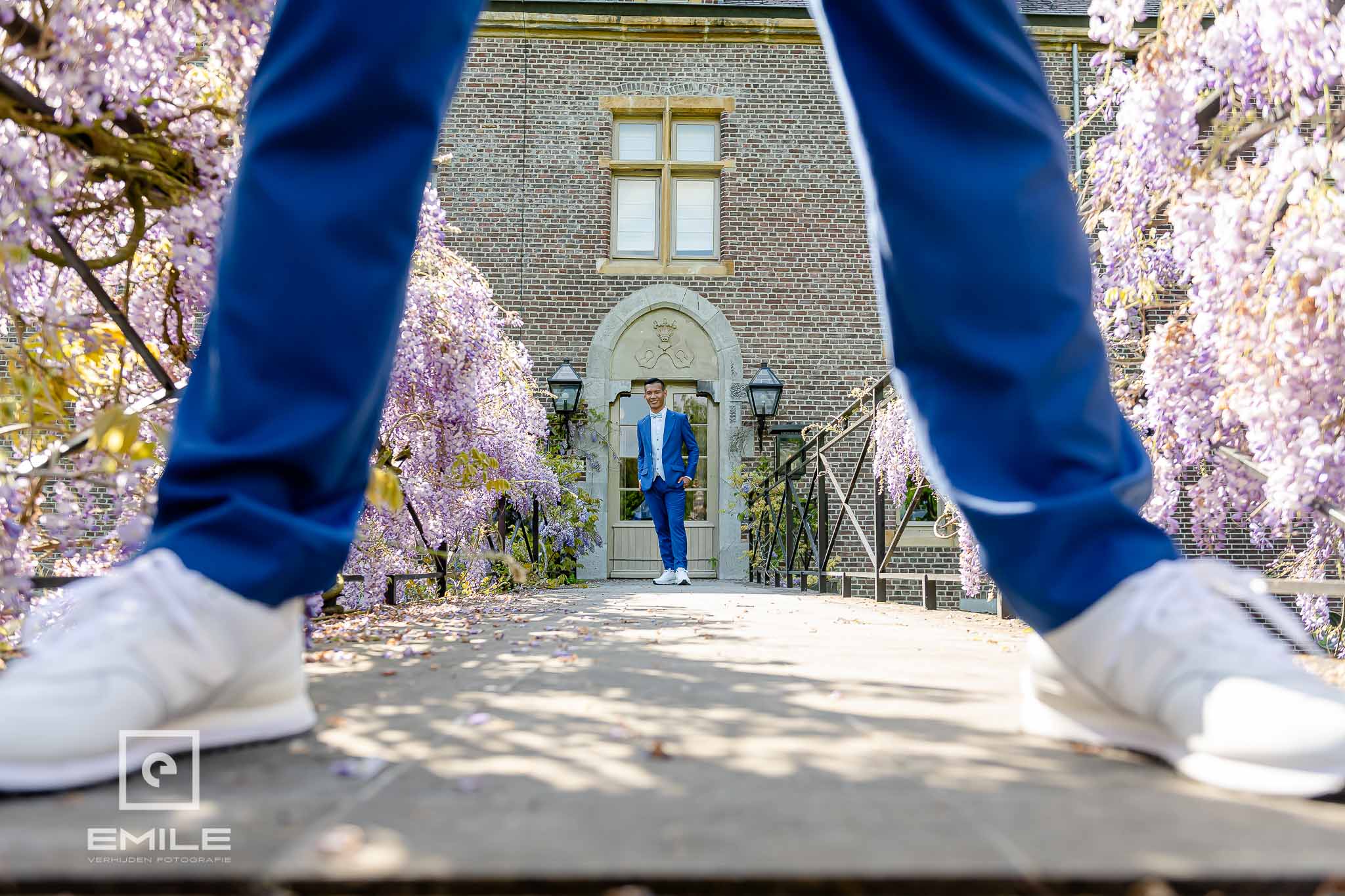 Door de benen gefotografeerd staat de andere partner bij de deur van het Kasteel - trouwfotograaf Heerlen 